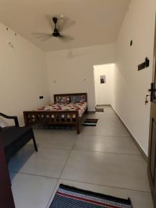 a bedroom with a bed and a ceiling fan at Moonlit Nest in Kappil