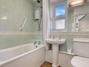 a bathroom with a sink and a tub and a toilet at Oxford House Porlock in Porlock +16 photos