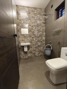 a bathroom with a toilet and a sink at Moonlit Nest in Kappil