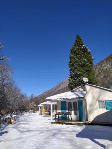 un edificio con tavolo da picnic nella neve di Camping Le Coulédous ad Aulus-les-Bains