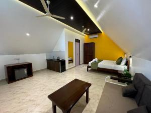 un soggiorno con un letto e un divano di Peace Garden Beach Resort a Canacona