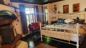 Un dormitorio con una cama y una silla dentro. en Little River Guest House, en Gabrovo