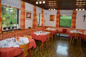 a restaurant with tables and chairs with red table cloth at Gästehaus Kreischberg - Mayer in Sankt Lorenzen ob Murau