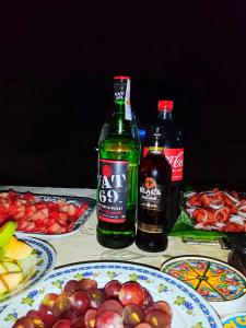 two bottles of soda sitting on a table with plates of food at Meemure Nature Camp in Hunnasgiriya