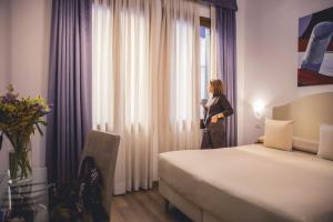 a woman standing in a hotel room looking out the window at Locanda Ca' Lucrezia in Venice