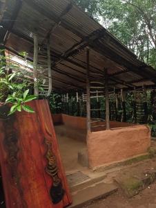 a large wooden structure with a roof and a plant at Meemure Nature Camp in Hunnasgiriya +12 photos