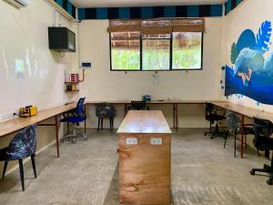 a classroom with desks and chairs in a room at Lexias Hostel and Workspace - Siargao in Catagnan