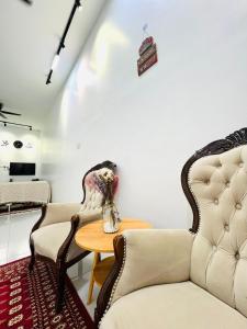 a living room with two chairs and a table at Inap Indah in Kuantan