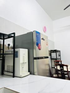 a kitchen with a refrigerator and a chair at Inap Indah in Kuantan
