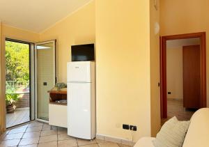 een keuken met een witte koelkast en een televisie. bij Holihome Vascello B21 in Tortoreto Lido