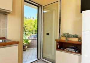een keuken met een glazen schuifdeur naar een patio bij Holihome Vascello B21 in Tortoreto Lido +22 foto's
