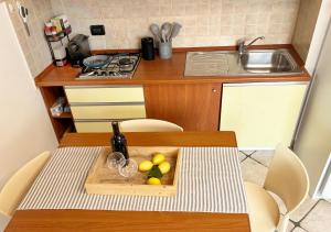 a kitchen with a table with a plate of fruit on it at Holihome Vascello B21 in Tortoreto Lido