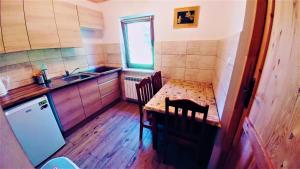 a small kitchen with a table and a sink at Chatka Bukowina in Wetlina