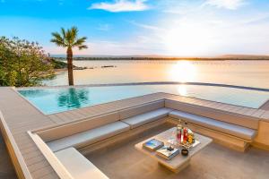 a swimming pool on a deck with a table at Artemare in Plemmirio +68 photos