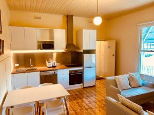 a kitchen and living room with a couch and a table at Point Lonsdale Guest House in Point Lonsdale