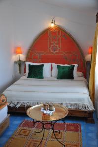 1 dormitorio con 1 cama grande y cabecero rojo en Dar Meziana, en Chefchaouen