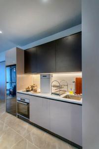 云顶高原Antara Genting by COBNB的厨房配有白色的柜台和黑色的橱柜