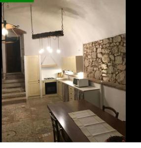 La Cantinetta في سان بيترو في كاريانو: مطبخ مع طاولة وجدار حجري