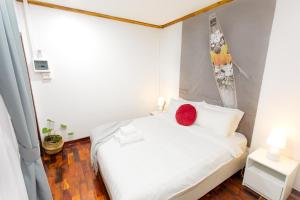 a bedroom with a white bed with a red pillow on it at BlueHome Free Laundry in Vientiane