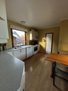 a kitchen with white cabinets and a wooden table at Guesthouse Leon in Tórshavn
