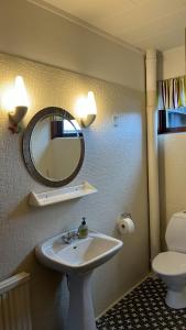 a bathroom with a sink and a mirror and a toilet at Guesthouse Leon in Tórshavn