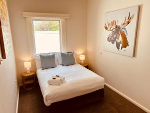 a bedroom with a bed with a stuffed animal on it at Point Lonsdale Guest House in Point Lonsdale