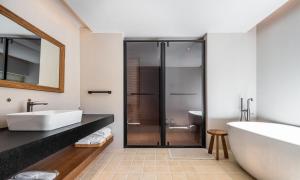 a bathroom with a tub and a sink and a shower at Siguniang Mountain Waiting for the Wind Snow Mountain Guesthouse in Mount Siguniang