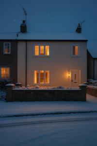 una casa con le luci accese nella neve di Relaxing Cottage Escape - Pub - Fire - King Size Bed a Newton Aycliffe