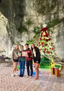 Un gruppo di persone che si trovano davanti a un albero di Natale. di Tam Cốc Valley Eco Resort a Ninh Binh