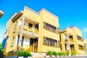 um grande edifício amarelo com varandas e plantas em DE ALena Villas And Hotel em Mbarara