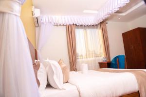 Um vestido de noiva está pendurado em frente a um quarto. em DE ALena Villas And Hotel em Mbarara