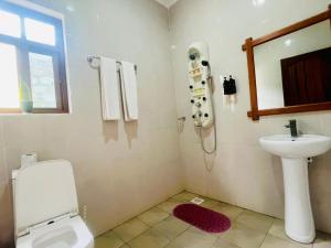 un baño con inodoro y lavabo en Sunset Retreat Hotel, en Arusha