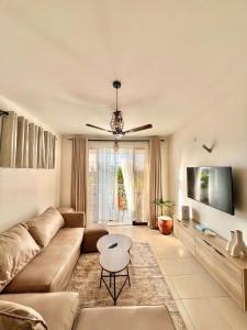 ein Wohnzimmer mit Sofa und Tisch in der Unterkunft Seville Stays Cozy Getaway in Mombasa