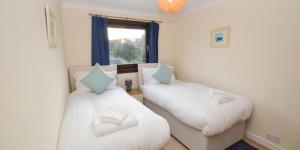 a bedroom with two beds and a window at An Cala in Connel