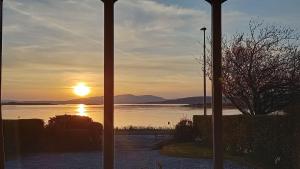 a view of the sunset from a room with a window at An Cala in Connel