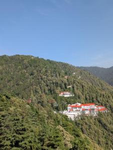 een groep gebouwen op de top van een berg bij Sahil cottage in Chamba