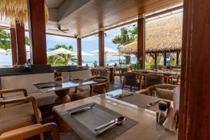 Um restaurante com mesas e cadeiras e vista para o oceano. em Muang Samui Spa Resort em Chaweng