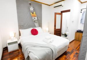 a bedroom with a large white bed with red pillows at BlueHome Free Laundry in Vientiane