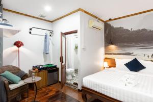 a hotel room with a bed and a chair at BlueHome Free Laundry in Vientiane