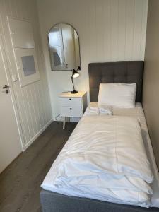 ein Schlafzimmer mit einem Bett mit Spiegel und Lampe in der Unterkunft Arctic Sea Apartments in Hammerfest + 16 Fotos