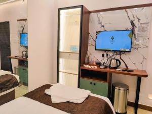 ein Zimmer mit einem Bett und einem Schreibtisch mit einem Fernseher in der Unterkunft Hotel Nova Grande' in Hosur + 40 Fotos