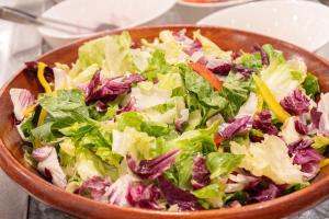 a salad in a wooden bowl on a table at CHECK inn Taichung Ziyou in Taichung