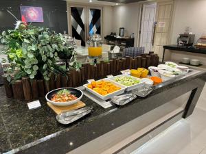 a buffet with fruits and vegetables on a counter at CHECK inn Taichung Ziyou in Taichung