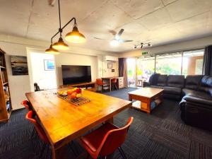 ein Wohnzimmer mit einem Holztisch und einer Couch in der Unterkunft Aloha Bayside in Highett