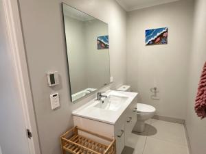 奥克兰Fairview Heights Sunny Deck Retreat的一间白色浴室，配有洗手池和镜子。