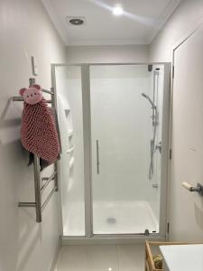 奥克兰Fairview Heights Sunny Deck Retreat的带玻璃门的浴室淋浴