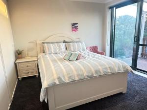 奥克兰Fairview Heights Sunny Deck Retreat的一间卧室，里面有一张床和一扇窗户。