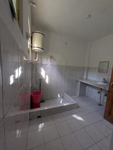 een badkamer met een douche, een wastafel en een tafel bij Sahil cottage in Chamba