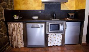 a kitchen with a microwave and a refrigerator at La Quintana de Antón in Jomezana +27 photos