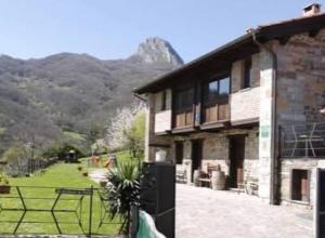 a building with a fence in front of a mountain at La Quintana de Antón in Jomezana